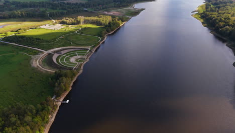 daugava river and amphitheater at likteņdarzs (garden of destiny) near the koknese castle in latvia. - aerial pullback shot