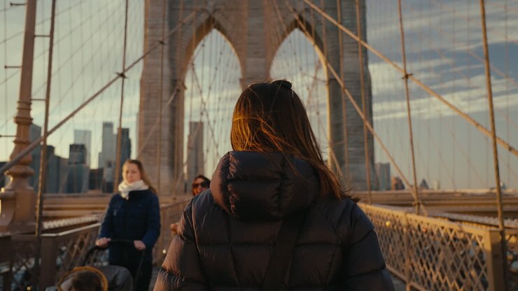 Woman Walking on Brooklyn Bridge at Sunset