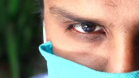 close-up of a man wearing a teal mask