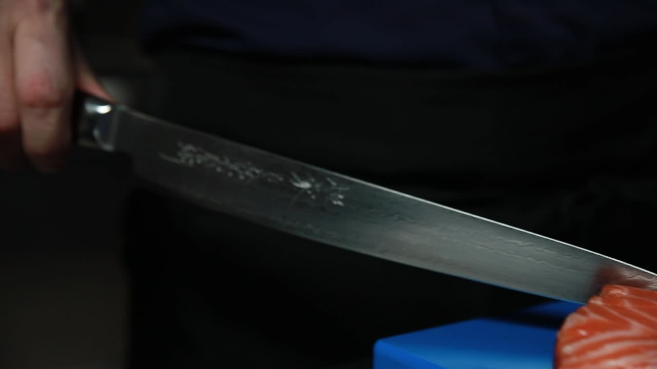 셰프가 연어 사시미를 준비하고 있습니다.