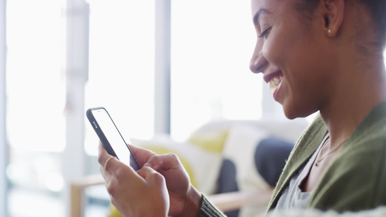 a young woman using a smartphone on the sofa