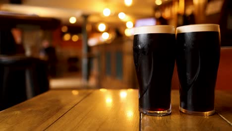 two pints of stout being picked up