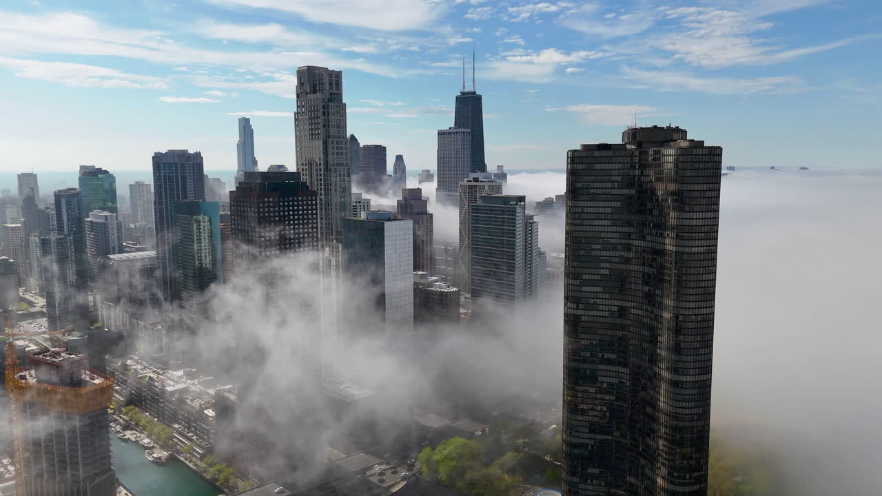 Aerial view circling the fog covering cityscape of Streeterville, sunny Chicago