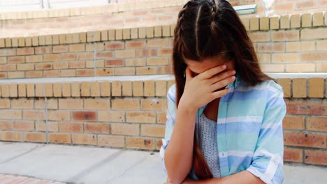 chica deprimida sentada en las escaleras en el campus