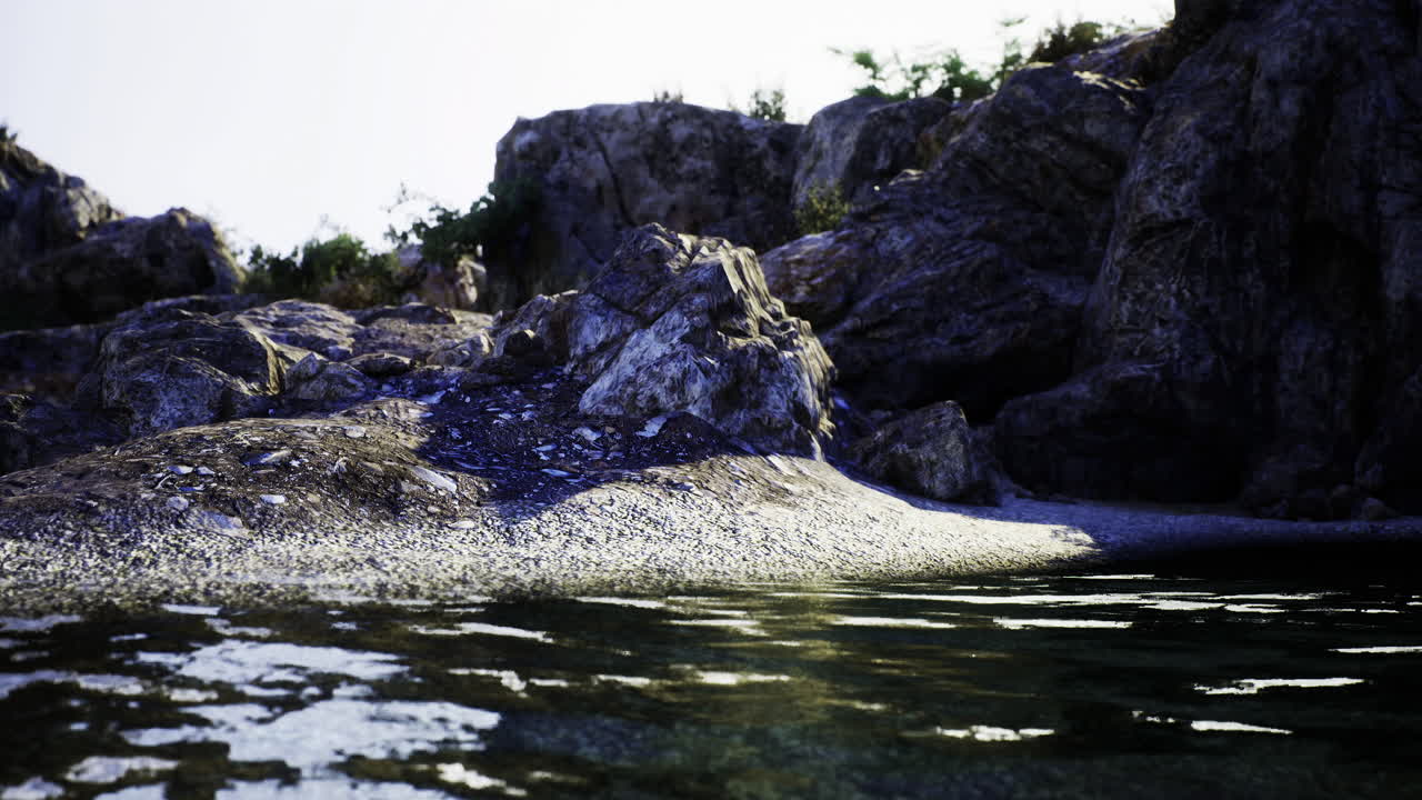 Calm rocky shoreline beside clear water in a serene natural setting