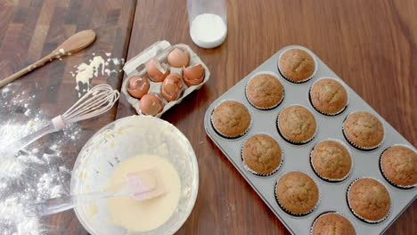 Pastelitos-Recién-Horneados,-Tazón-Para-Mezclar,-Utensilios-E-Ingredientes-Usados-En-La-Encimera-De-La-Cocina,-Cámara-Lenta