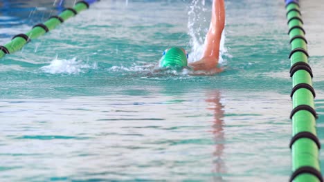 fit swimmer doing the back stroke in the swimming pool