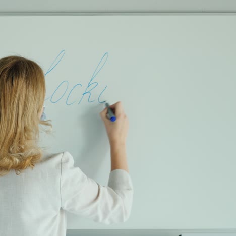 una mujer escribe una palabra bloqueo en el tablero de clase