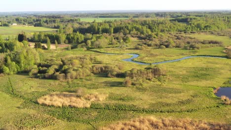 Tranquil-drone-footage-of-a-river-and-lush-farm-fields-in-Europe