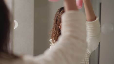 woman drying her hair in bathroom