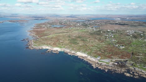 ballyconneely 근처의 mannin bay에 위치한 산호 해변의 영화 드론 영상, 멀리있는 집을 드러내는 넓은 회전 공중 촬영
