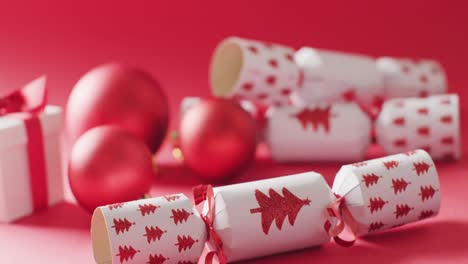 video of christmas red baubles and crackers on red background