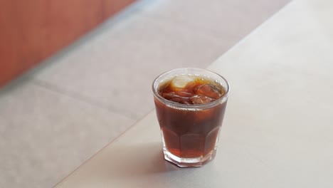 a glass of iced coffee on a table