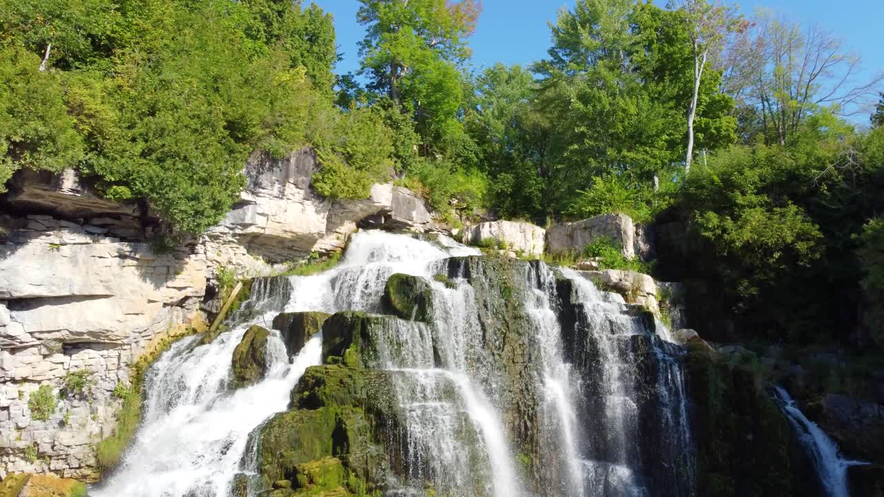 Avvicinamento alle cascate Inglis con una ripresa da drone e leggera inclinazione per catturare l'acqua che scorre a valle, situate nella Georgian Bay, Ontario, Canada