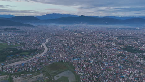 Aerial view of Kathmandu, Nepal, flooded by cloudburst, with horizon visible. The unmanaged urban infrastructure suffers severe damage, dire effects of the climate crisis on the valley’s landscape