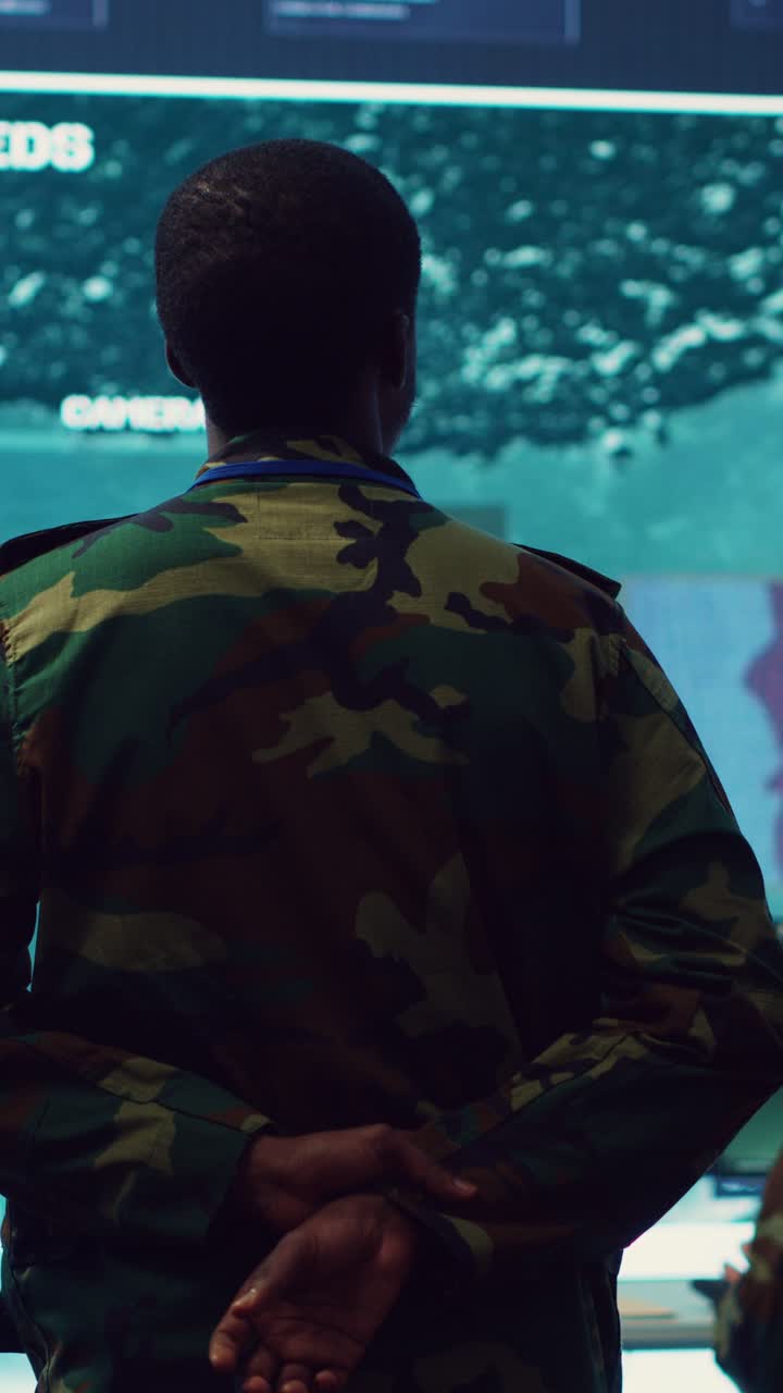 Soldier in Camouflage Uniform Observing Satellite Link in Control Room