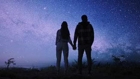 pareja mirando el cielo estrellado de la noche