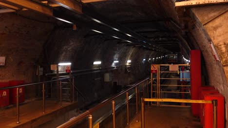 a red and white train going through a brick tunnel.