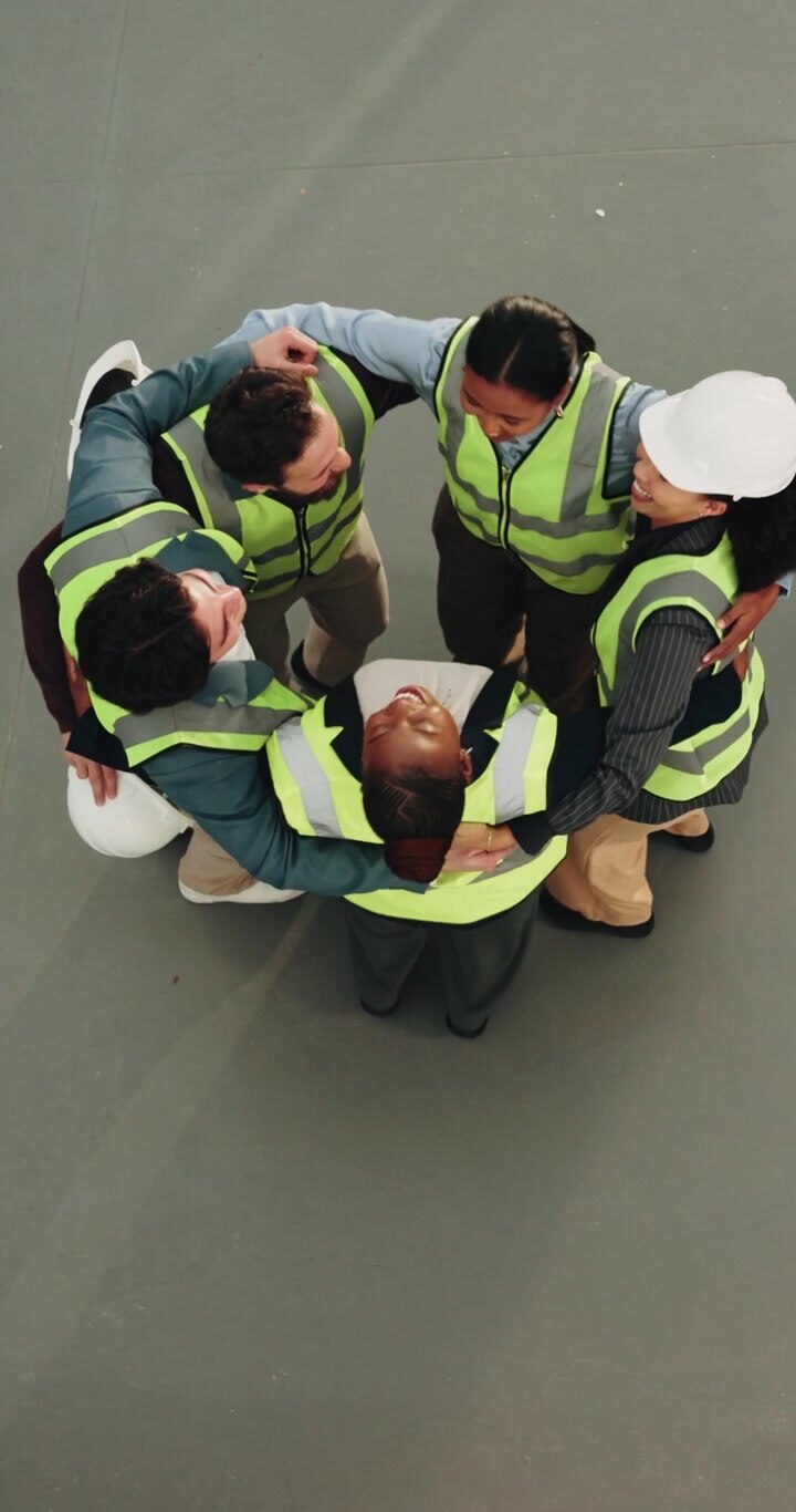 Team eterogeneo di operai edili riunito in un momento di festeggiamento