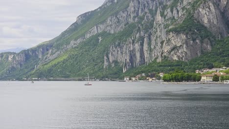 a sailing boat in the distance in lake como, shot in overcast weather.