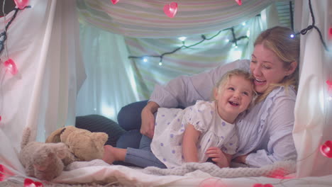 Young-daughter-joining-mother-in-homemade-camp-in-child's-bedroom-at-home---shot-in-slow-motion