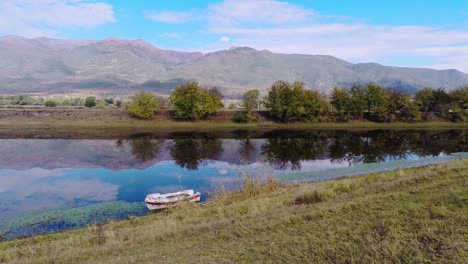 View-of-a-river-next-to-a-mountain-on-a-cloudy-day-with-a-boat-in-it