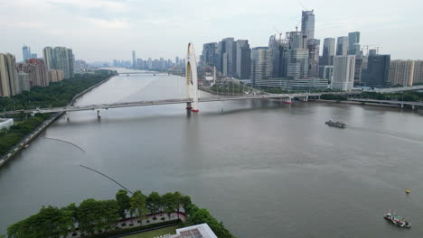 Der-Verkehr-überquert-Die-Brücke,-Während-Boote-Den-Fluss-In-Guangzhou,-China,-Durchstreifen