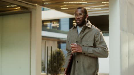 man walking in modern office building with coffee