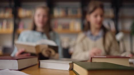 two girls reading books in a library