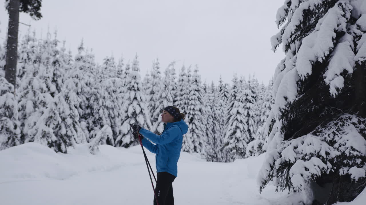Donna che pratica sci di fondo in una foresta innevata