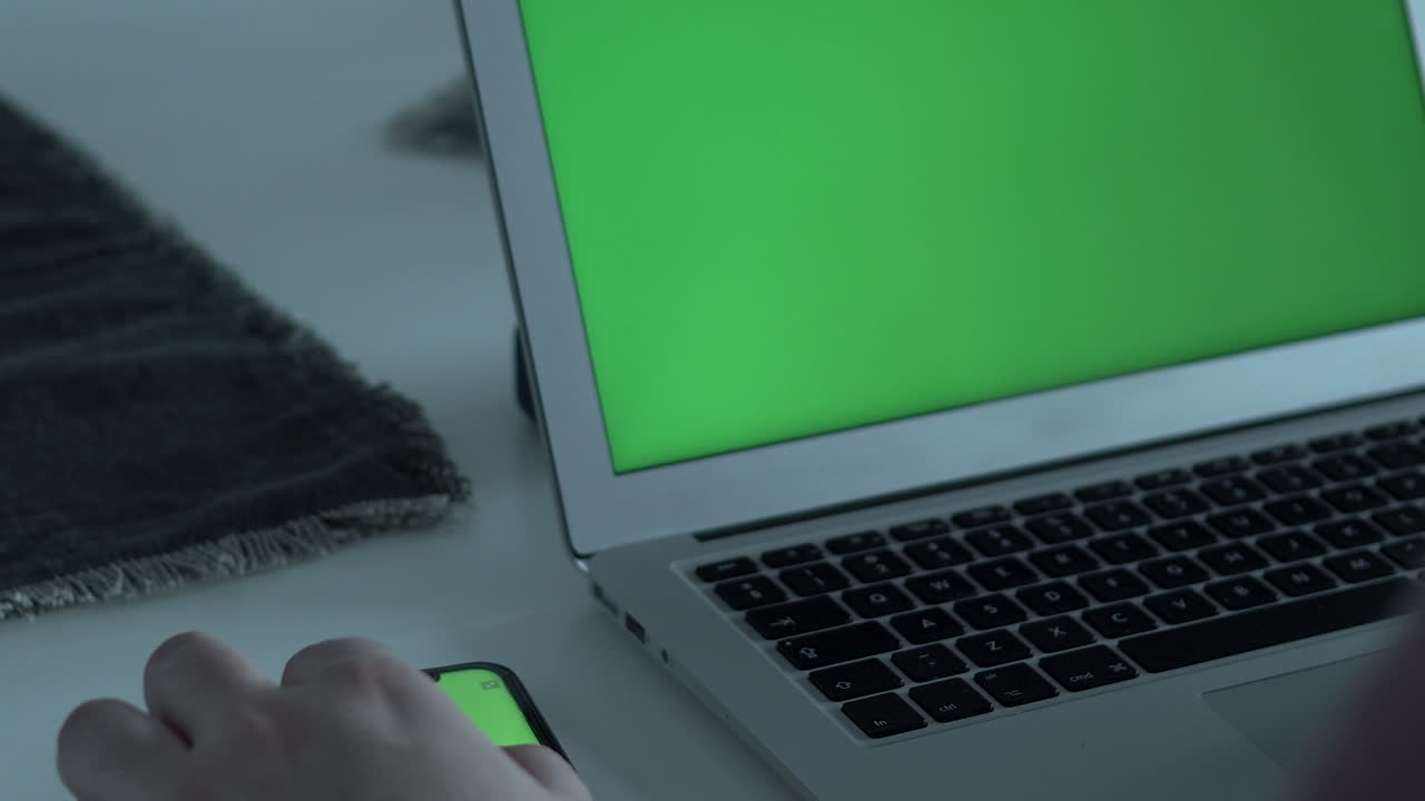 primer plano ajustado, tocar la pantalla del móvil y escribir en el teclado del portátil