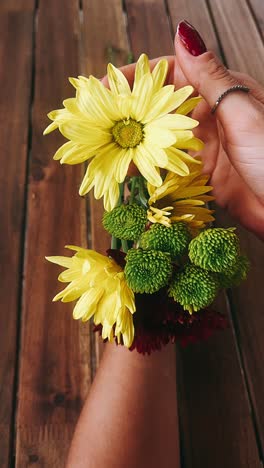 woman holding a colorful flower bouquet on a wooden table