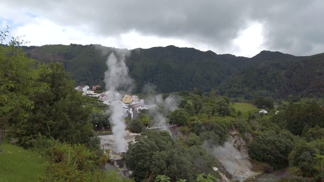 Top view of the active geysers and fuming hot springs at natural landmark &amp;quot;Caldeiras das Furnas&amp;quot; in Furnas, San Miguel Island, Azores, Portugal with hortensia flowers in the foreground