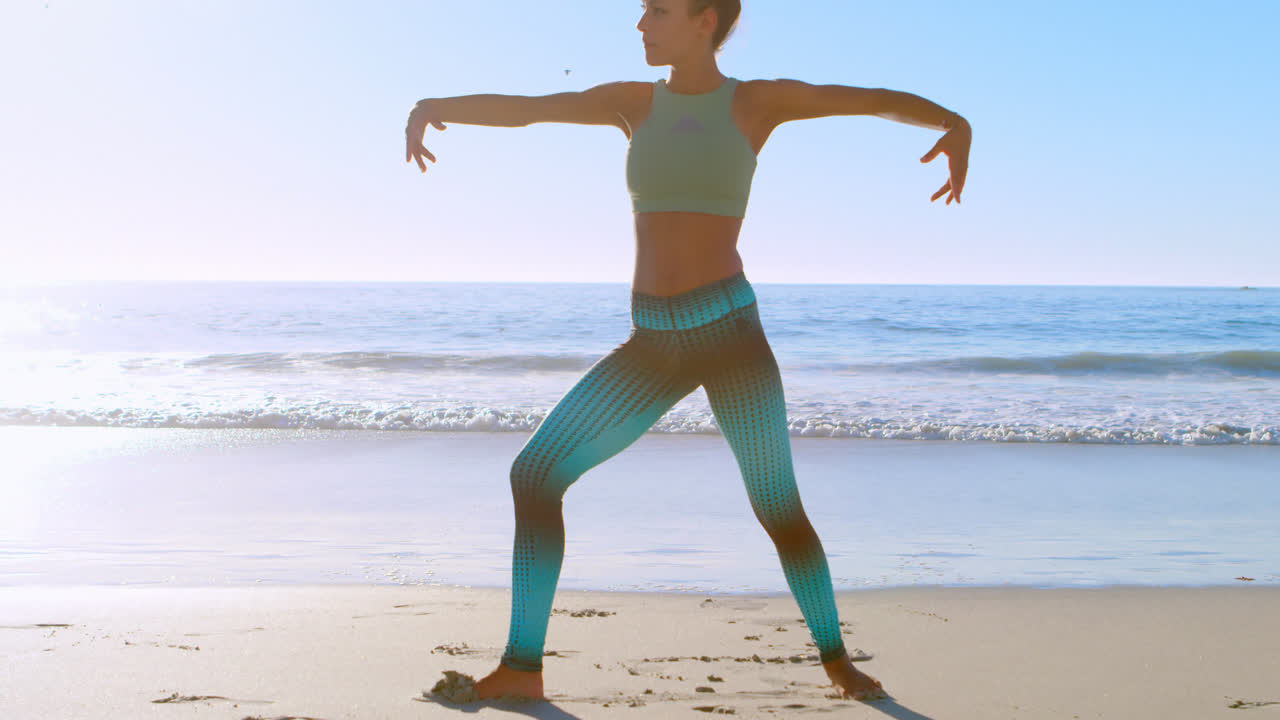 mujer realizando yoga en la playa 4k