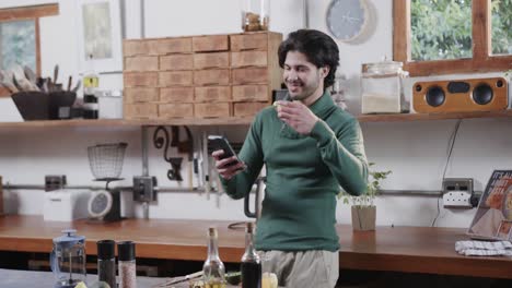 caucasian man eating avocado toast and using smartphone in kitchen, slow motion