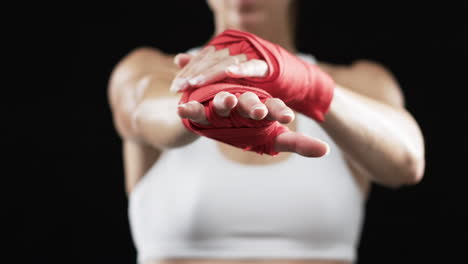 young caucasian woman boxer in a fighter's stance on a black background