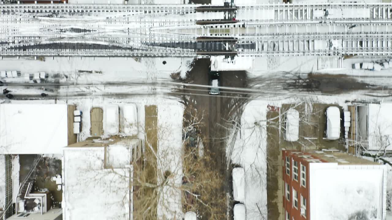 Aerial, tracking shot of black car driving on city streets