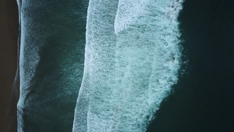 Overhead-view-of-waves-crashing-onto-a-beach