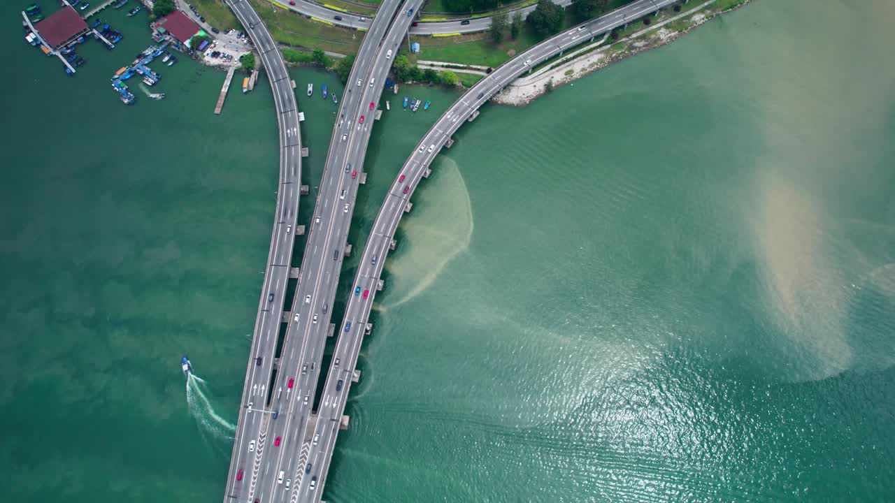 Top down drone aerial view of highway leading onto a bridge crossing over water