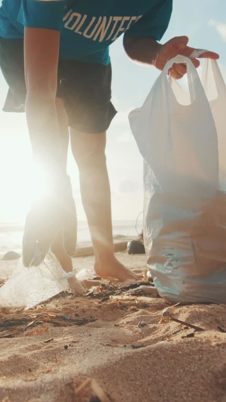 Cropped woman volunteer from eco community removes plastic trash from beach