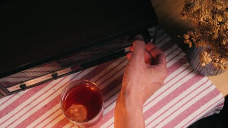 tuning a vintage radio with a drink