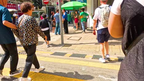 people crossing a bustling street in hong kong