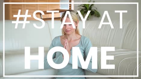 Caucasian-woman-practicing-yoga-at-home-during-coronavirus-pandemic-with-words-Stay-Home