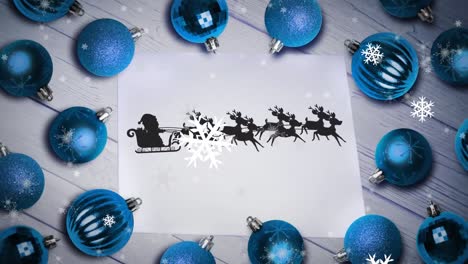 Animation-of-santa-claus-in-sleigh-with-reindeer-over-snow-falling-and-blue-christmas-baubles