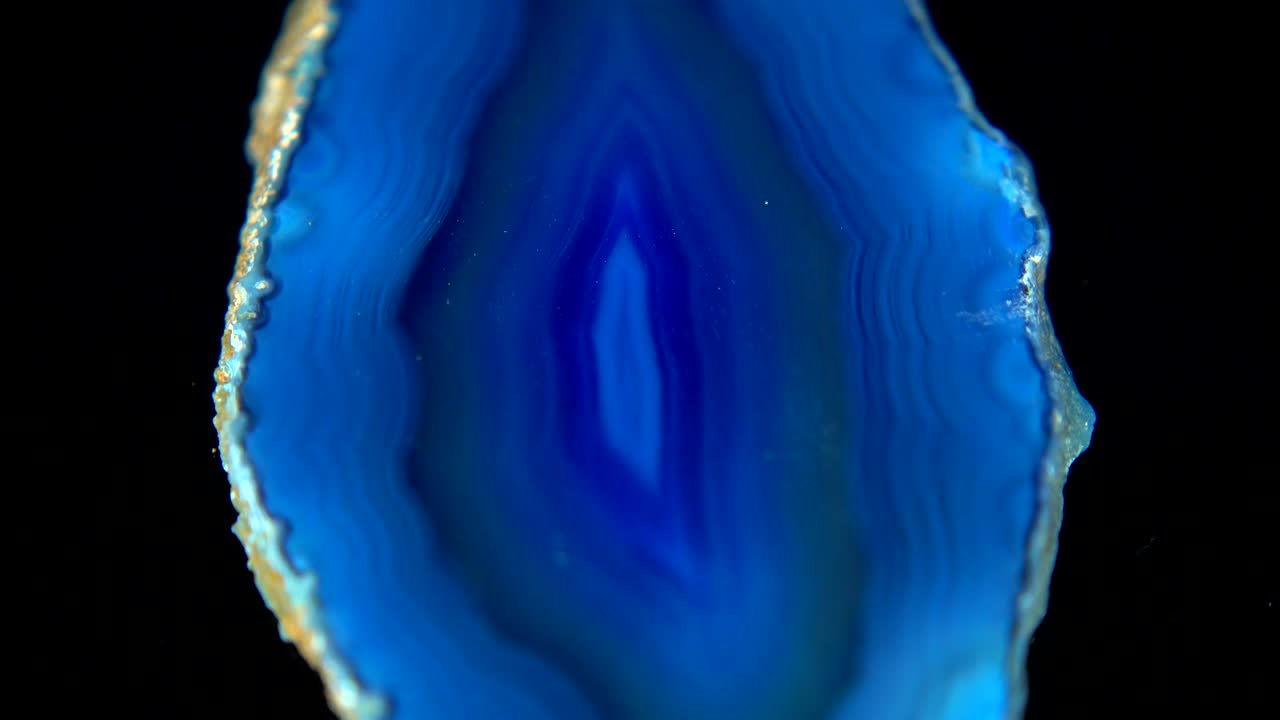 mineral azul oscuro (agata azul) que gira sin problemas frente a un fondo negro