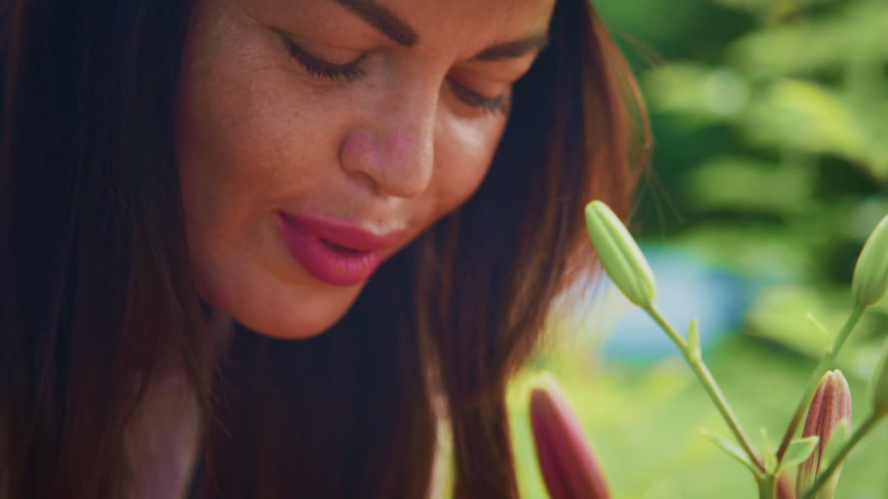 Woman enjoying the beauty of blooming flowers in a vibrant garden filled with colors