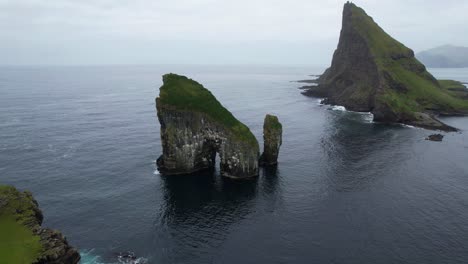 órbita-Aérea-Alrededor-De-Drangarnir-Revelando-Su-Arco-Con-Tindholmur-Detrás