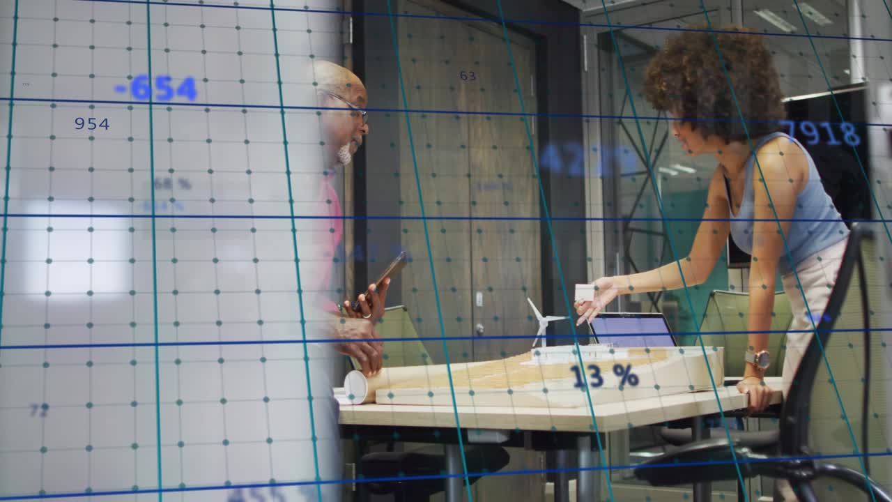 Man checking phone and turbine model in lab leading woman joining adjusting part blue grid labeling