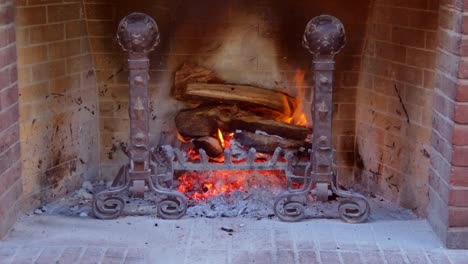 Cerca-De-Un-Fuego-De-Leña-Ardiendo-En-Una-Chimenea-De-Estilo-Antiguo-Con-Un-Cálido-Resplandor-De-Las-Brasas-Y-Cenizas