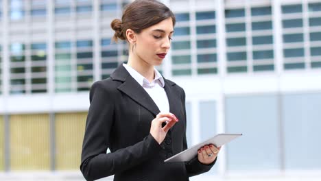 mujer de negocios sonriente usando una tableta digital al aire libre